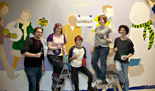 Cartoonists painting a mural
