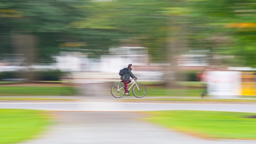Dartmouth student rides a bike across campus. 