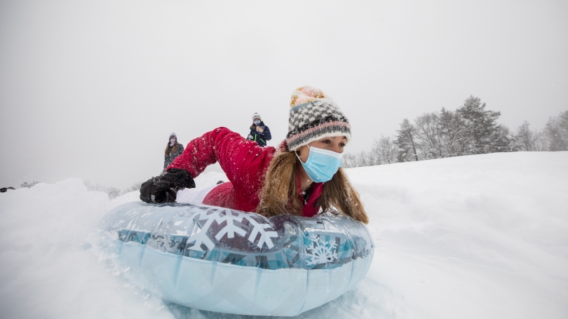 Dartmouth student sleds down a hill on December 16, 2020